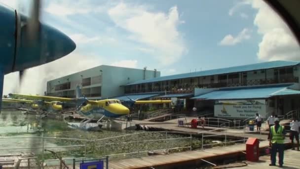 Vis de l'avion jaune-bleu tourne sur le fond de la jetée . — Video