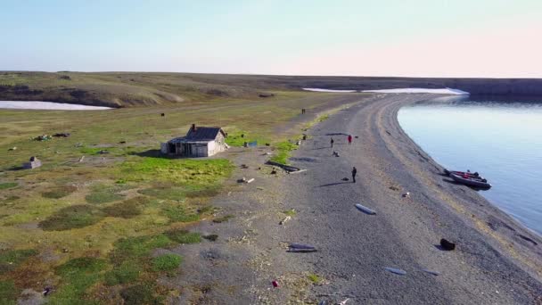 Personnes à proximité d'une maison isolée sur l'île désolée de Vaygach dans le désert . — Video