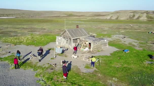 Menschen in der Nähe eines einsamen Hauses auf der trostlosen Insel Aygach in der Wüste. — Stockvideo
