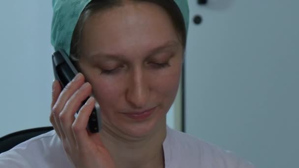 Sjuksköterska talar på mobiltelefon på klinik. — Stockvideo