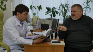Beyaz önlük Doktor şişman adam hastada klinik danışır.