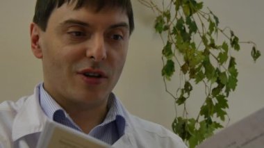 Hastane kartı modern kliniğinde Beyaz paltolu doktorun elinde.
