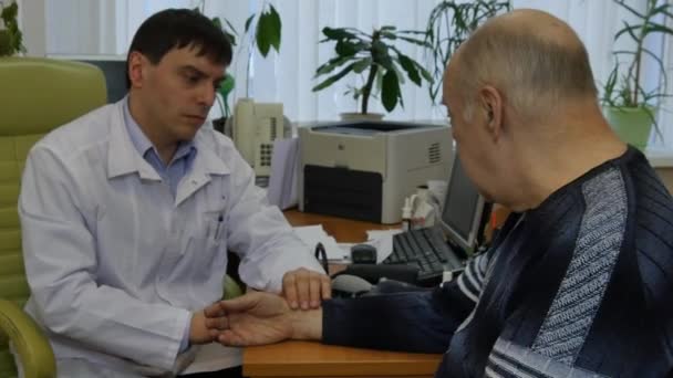 Врач в белом халате консультирует пациента мужского пола в клинике . — стоковое видео