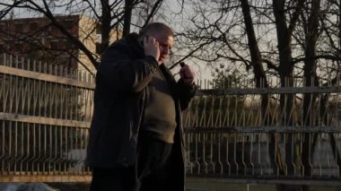 Şişman bir adam telefonda konuşan ve şehir sokak üzerinde çok sinir.