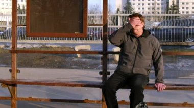 Adam birden baş ağrısı ve şehir otobüs durağında ani giddiness sokak hissettim.