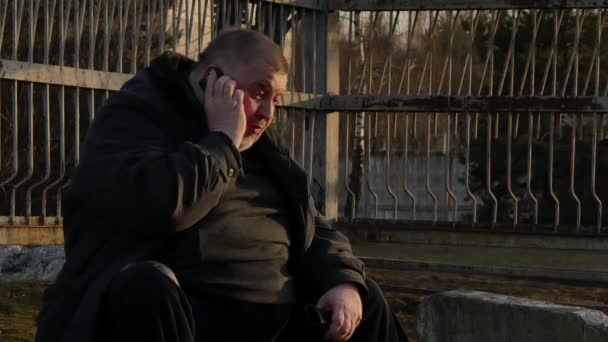 Толстяк говорит по телефону и очень нервничает на городской улице. . — стоковое видео