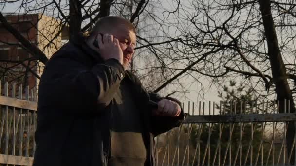 Dicker Mann ist nervös beim Telefonieren auf der Straße. — Stockvideo