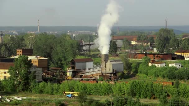 Buizen van fabrieksinstallaties rook onder de groene bomen en natuur in Alapajevsk. — Stockvideo