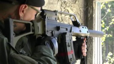 Silah ile askeri üniformalı asker bir harap evin bir penceredir.