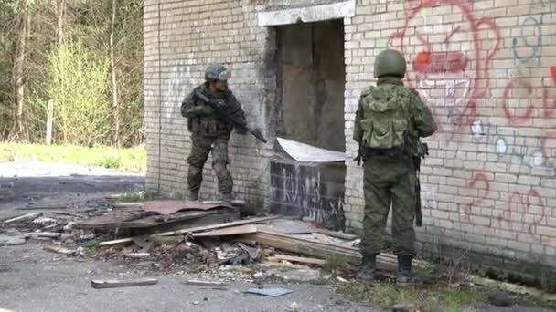 Soldados en uniforme militar con armas en el fondo de la casa en ruinas. — Vídeos de Stock
