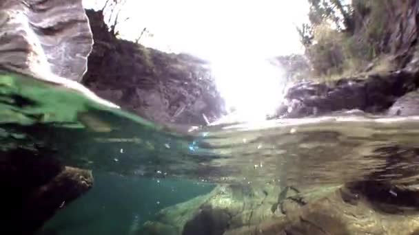 Air transparan sungai Verzasca di latar belakang batu-batu besar halus . — Stok Video