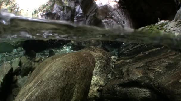 Transparentes Wasser des Flusses Verzasca auf dem Hintergrund riesiger glatter Steine. — Stockvideo