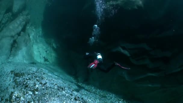 Kameran operatören dykare under vattnet i genomskinliga floden Verzasca. — Stockvideo
