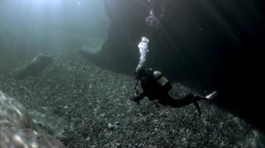 Kırılma Verzasca Nehri'nde su altında güneş ışığı içinde kamera operatörü.