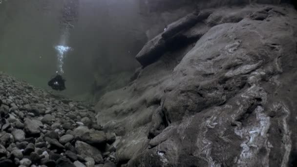 Divers with camera underwater in transparent river Verzasca. — Stock Video