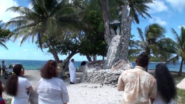 Des gens près d'un arbre religieux avec des coquillages . — Video