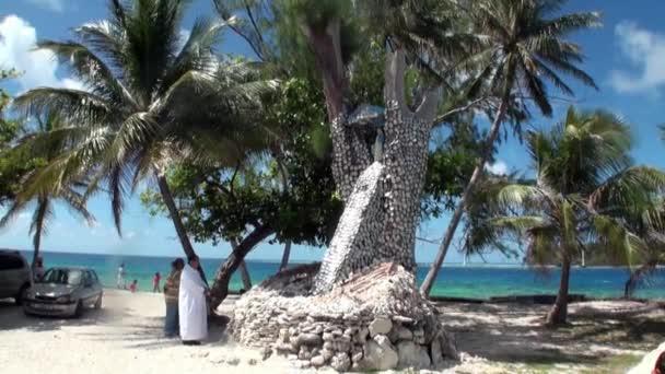 Des gens près d'un arbre religieux avec des coquillages . — Video