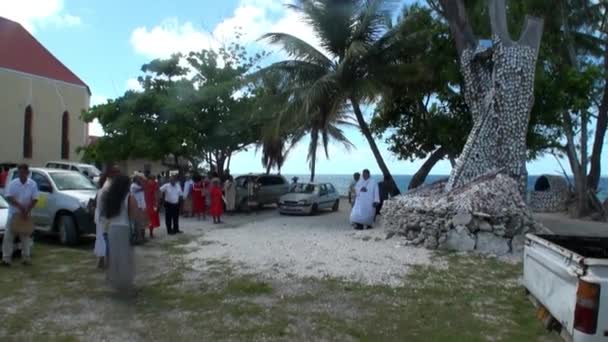 Menschen in der Nähe religiöser Bäume mit Muscheln. — Stockvideo