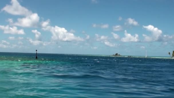Klares Wasser des azurblauen Ozeans vor blauem Himmel und weißen Wolken. — Stockvideo