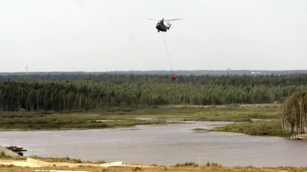 Helicóptero de incêndio de carga com concha suspensa leva água do reservatório . — Vídeo de Stock