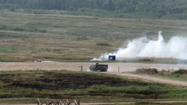 Ryska militära stridsmaskin rider på vägen på bakgrund av skog. — Stockvideo