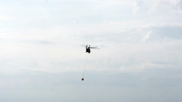 Vracht brandweerhelikopter met gesuspendeerde lepel vliegt uit reservoir. — Stockvideo