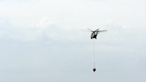 Helicóptero de incêndio de carga com concha suspensa está voando do reservatório. — Vídeo de Stock