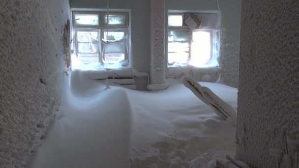 Ventanas congeladas y habitaciones cubiertas de nieve en la casa en ruinas en la ciudad desierta . — Vídeo de stock