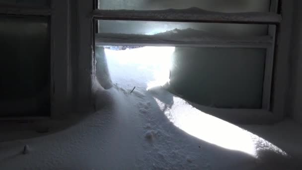 Neve em janelas congeladas quebradas de casa abandonada na cidade deserta . — Vídeo de Stock