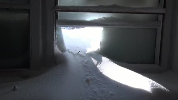 Snow in a broken frozen windows of abandoned house in deserted city. — Stock Video