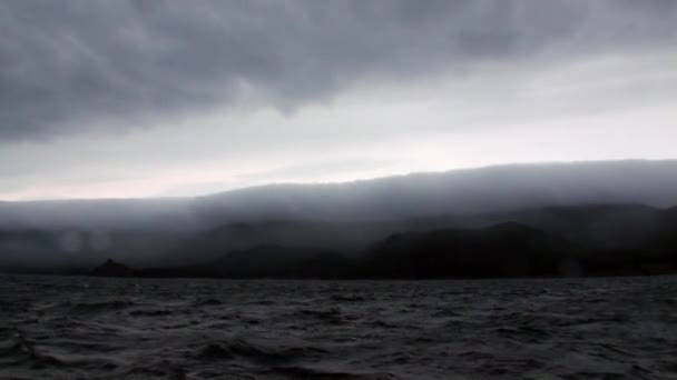 Sturm auf dem Hintergrund von grauen Wolken am Himmel und schwarzem dunklen Wasser des Baikalsees. — Stockvideo