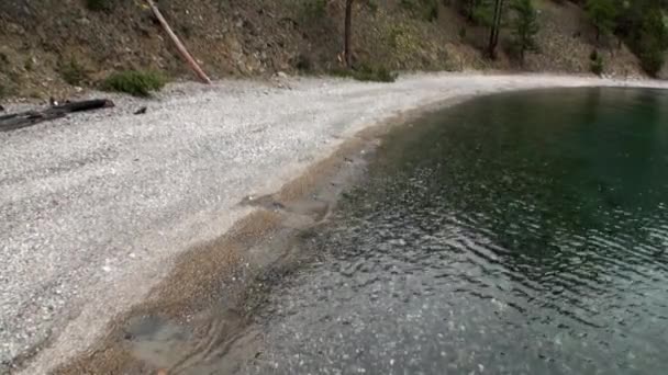 Pierre lisse en gros plan sous l'eau transparente propre sur la côte du lac Baïkal . — Video