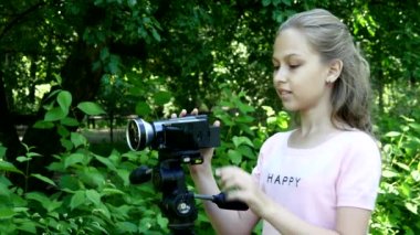 Genç kız video kameraya yeşil park arka plan arka plan üzerinde görünüyor..