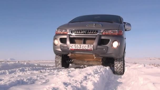 Snowdrifts and car on road in Anadyr city on far north. — Stock Video