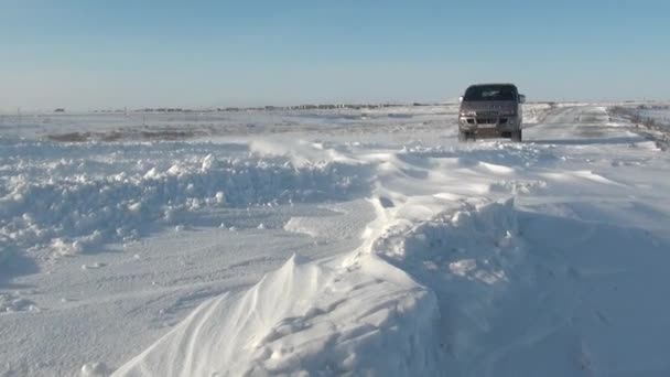 Snowdrifts and car on road in Anadyr city on far north. — Stock Video