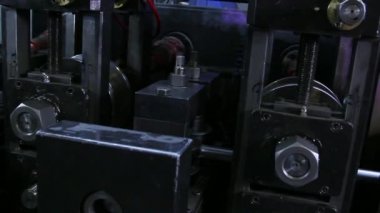 Fabrikadaki metal çelik boruların yapımında kullanılan metal rulo makinelerin yakın çekim görüntüleri..
