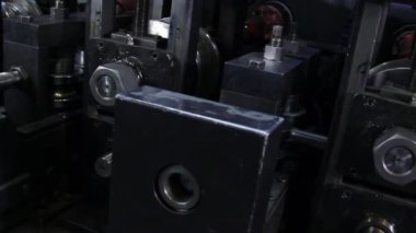 Fabrikadaki metal çelik boruların yapımında kullanılan metal rulo makinelerin yakın çekim görüntüleri..