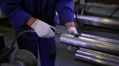 Paslanmaz çelik borularda fabrika arka plan üzerinde çalışan eller.