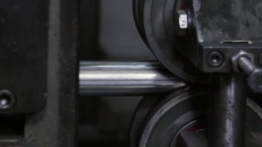 Fabrikadaki metal çelik boruların yapımında kullanılan metal rulo makinelerin yakın çekim görüntüleri..