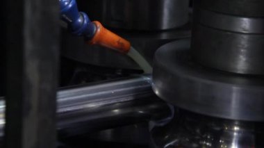 Fabrikadaki metal çelik boruların yapımında kullanılan metal rulo makinelerin yakın çekim görüntüleri..