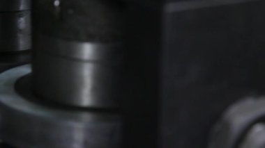 Fabrikadaki metal çelik boruların yapımında kullanılan metal rulo makinelerin yakın çekim görüntüleri..