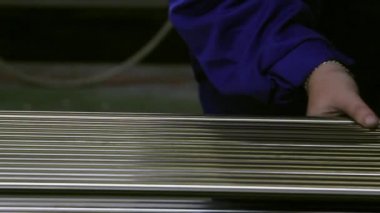 Paslanmaz çelik borularda fabrika arka plan üzerinde çalışan eller. Metal haddeleme makineleri haddelenmiş metal parçaları veya bağımsız bir öğe üretimi için kullanılan üretim için.