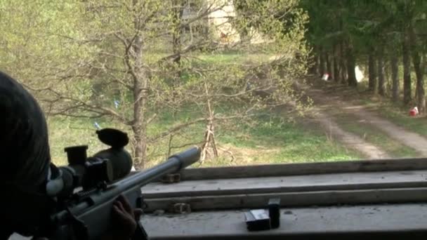 Ελεύθερος σκοπευτής με στρατιωτικές στολές με όπλο σε κατεστραμμένο σπίτι.. — Αρχείο Βίντεο