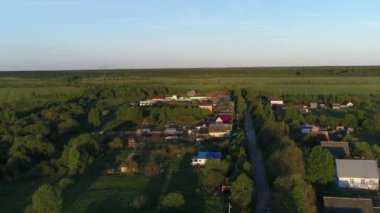 Büyüleyici manzara manzarası olan yeşil otlaklarla çevrili nehir üzerinde evleri ve bahçeleri olan bir köy manzarası. Açık hava iklimi kavramı.