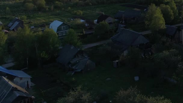 Wideo z lotu ptaka panorama wsi z domami i ogrodami na rzece otoczonej zielonymi pastwiskami z przepięknym krajobrazem z widokiem na kino. Concept climate outdoor nature. — Wideo stockowe