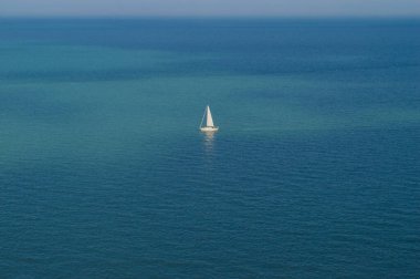 Mavi denizin ortasında, beyaz yelkenli bir yelkenli..