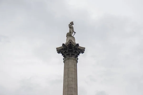 Isolated shot of Nelson\'s Column in Trafalgar Square, London, England with cloudy overcast sky. Built in 1843 to commemorate Admiral Horatio Nelson