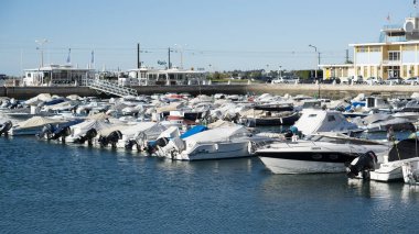 Güneşli bir günde Portekiz 'in Algarve kentindeki Faro kasabasının limanında beyaz tekne sıraları..