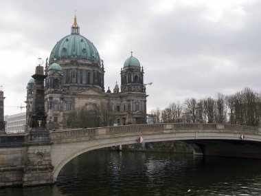 Berlin Katedrali / Berliner Dom ve Schloss Köprüsü / Schlossbrucke, Berlin, Almanya 'da, Kupfergraben Kanalı' na kış sonu / bahar başında bulutlu bir günde bakmaktadırlar..