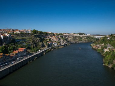 Porto 'daki Douro Nehri boyunca güneşli bir yaz gününde mavi gökyüzüne bakan Henrique Köprüsü' ne bakın.